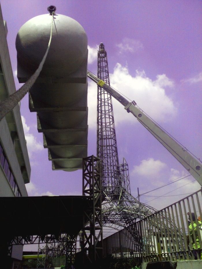 Maquinaria industrial junto a una alta plataforma de perforación bajo un cielo púrpura