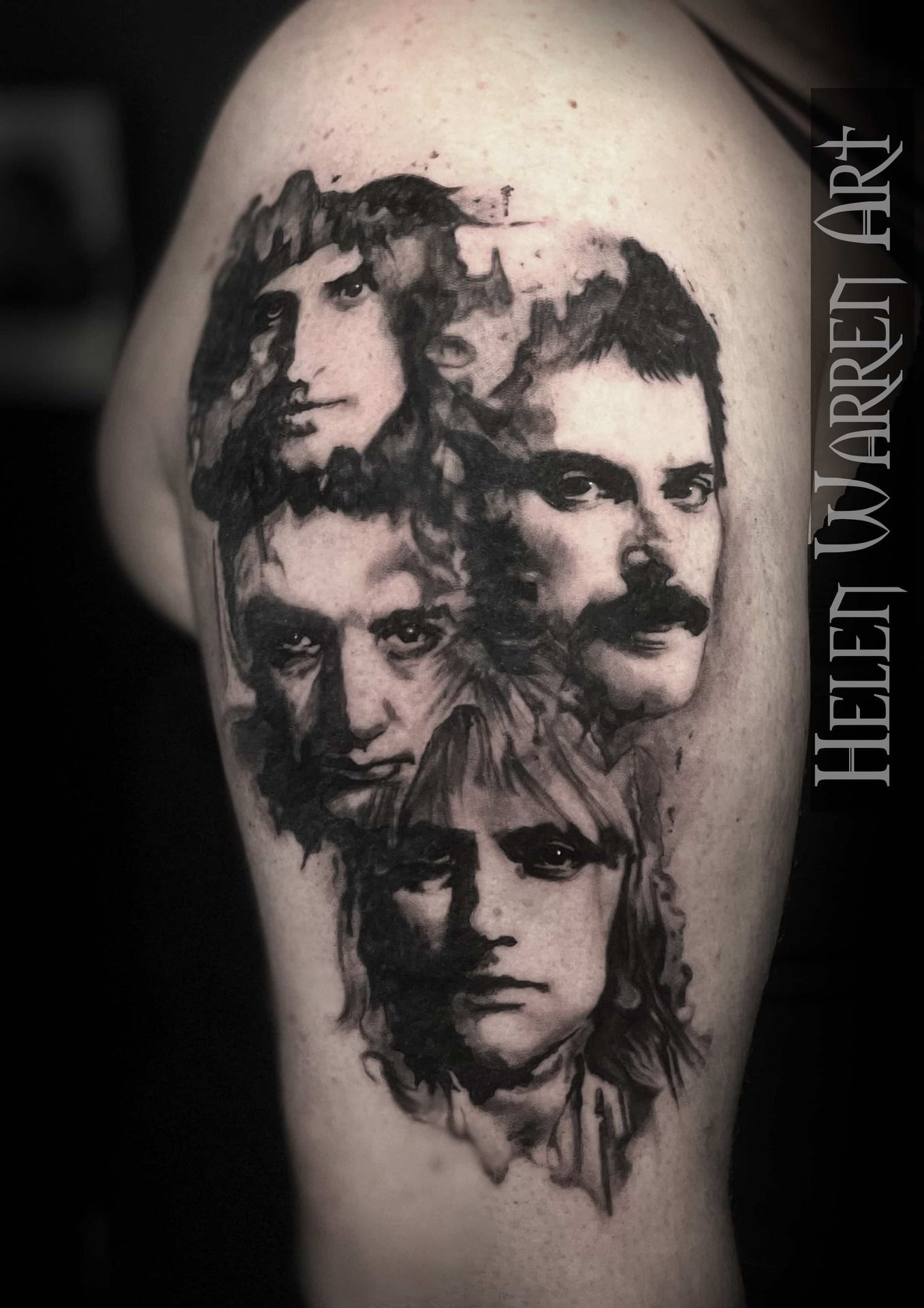 Queen band members portrait tattoo on arm, black and white.