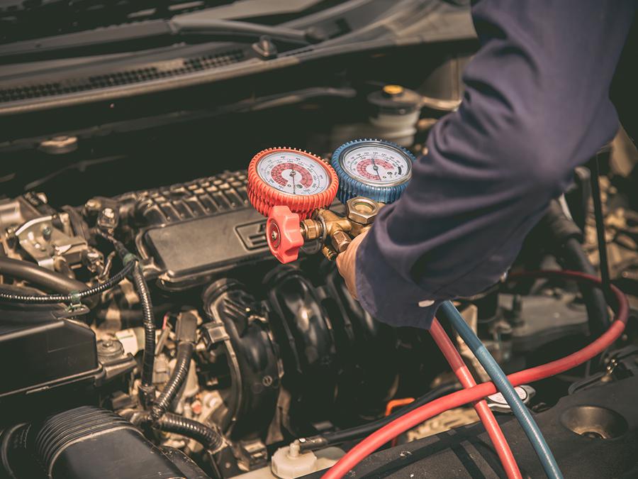 A man is working on the engine of a car.