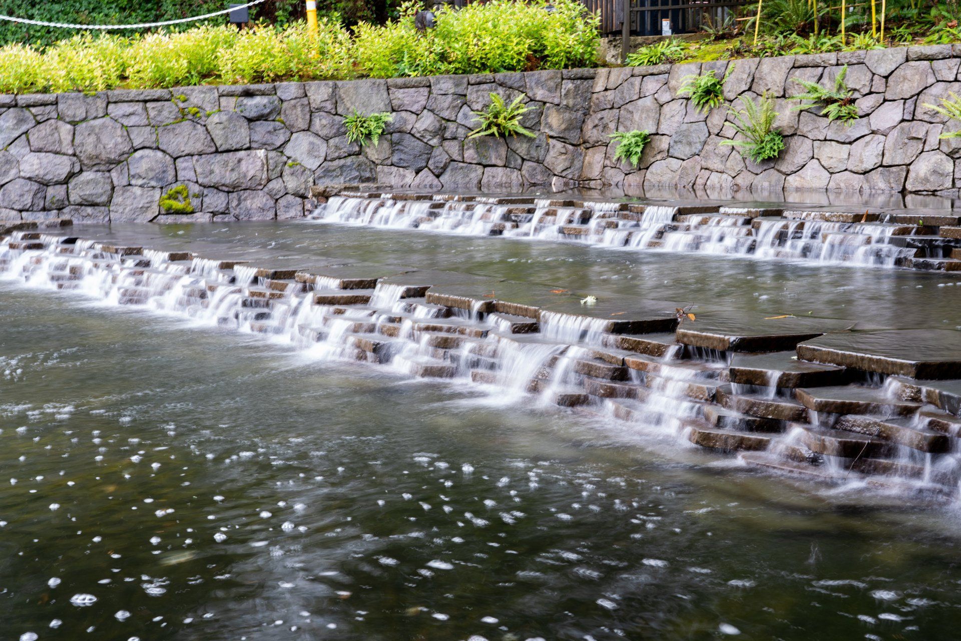 Water cascading down tiered stone structures in a man-made stream. 