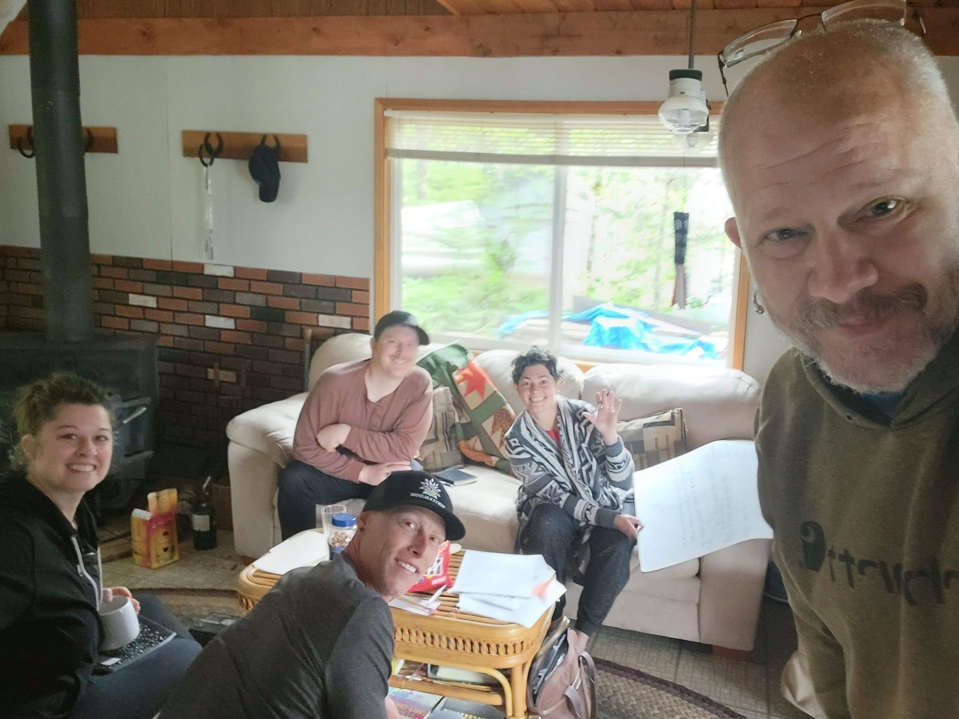 A group of six people in a cozy living room, smiling at the camera.