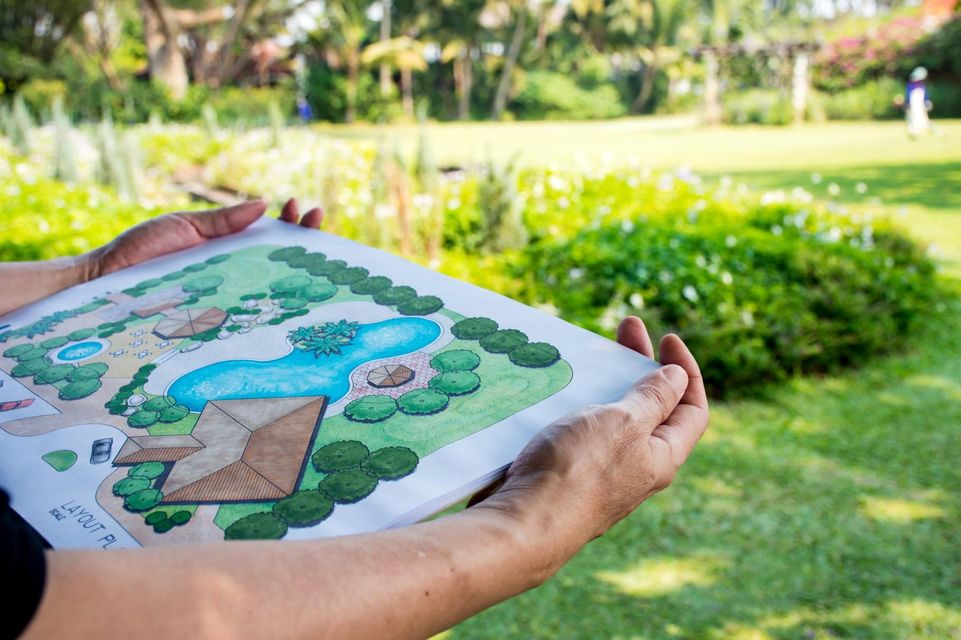 Hands holding a color landscape design plan.
