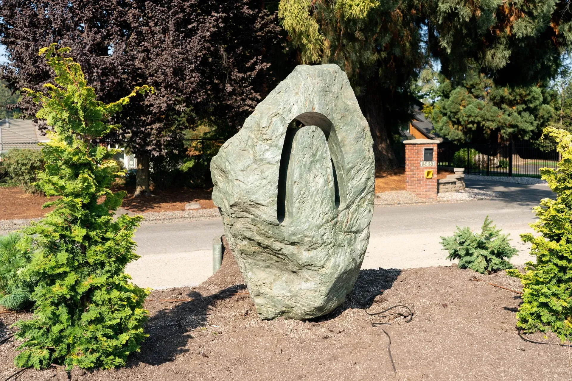 A large, textured stone sculpture with a central U-shaped cut.