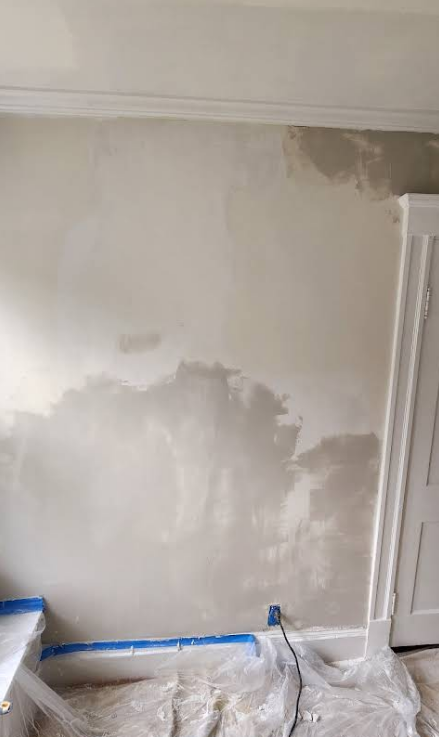 Wall with damp-looking patches. 