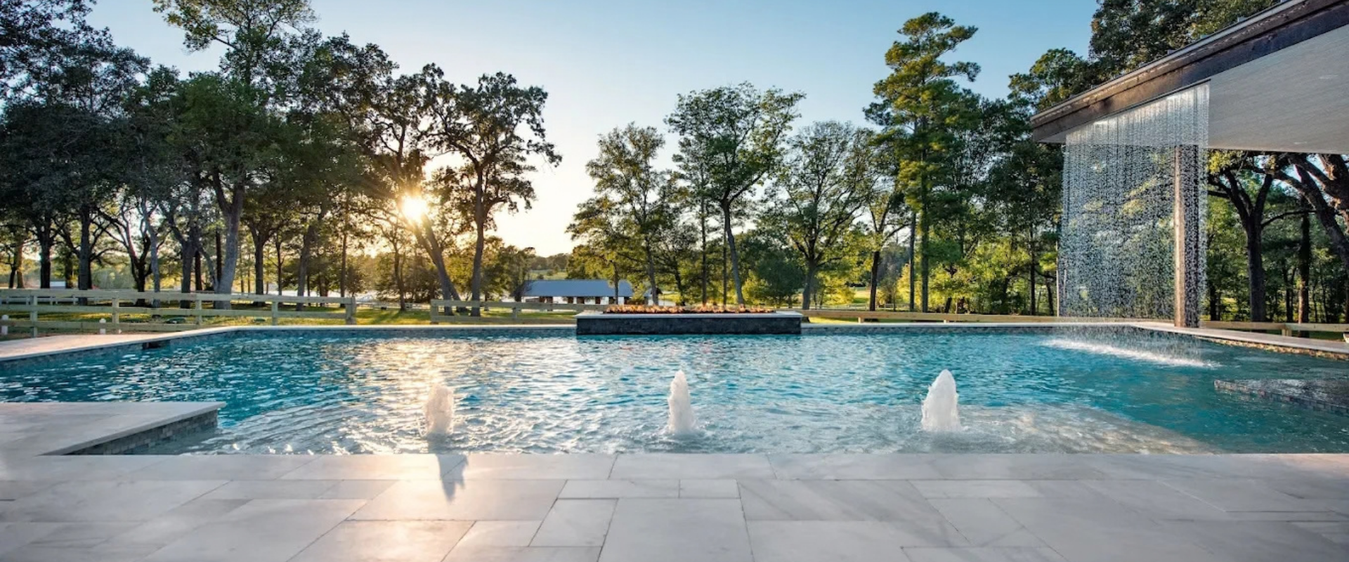 Modern geometric pool with sheer descent waterfall and bubblers in Houston Texas