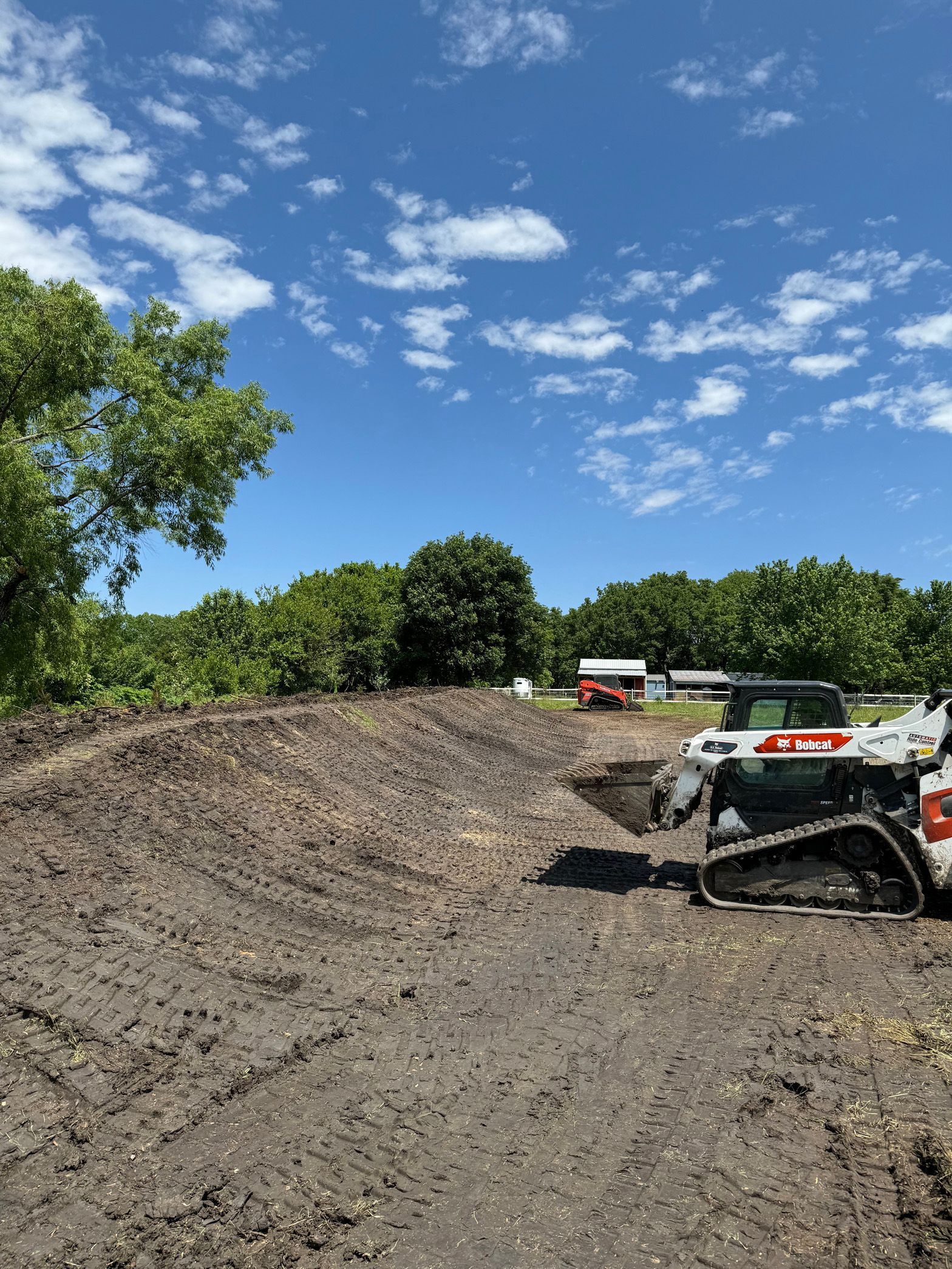 A bulldozer is sitting in the middle of a dirt field.