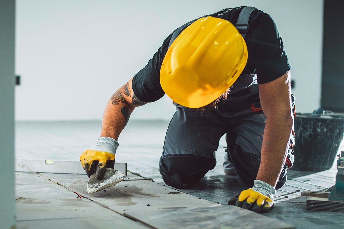 Man Installing Tiles — Houston, TX — Sandtech – S. T. Construction Corp.