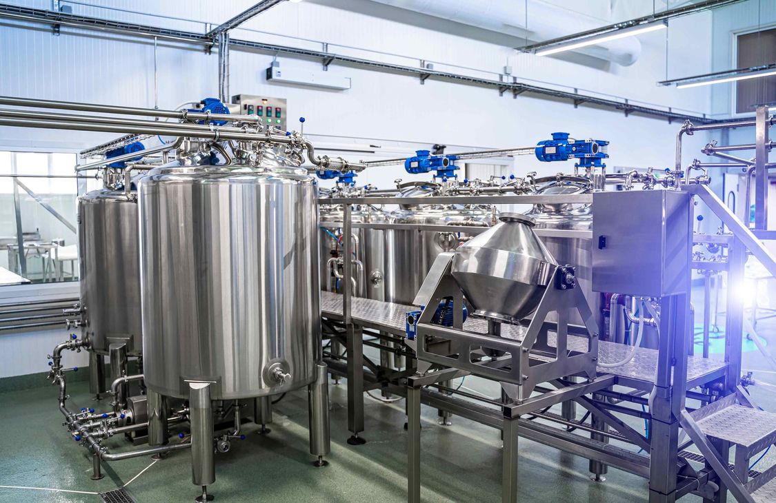 Interior of a dairy factory with a fermentation tank, showcasing dairy equipment.