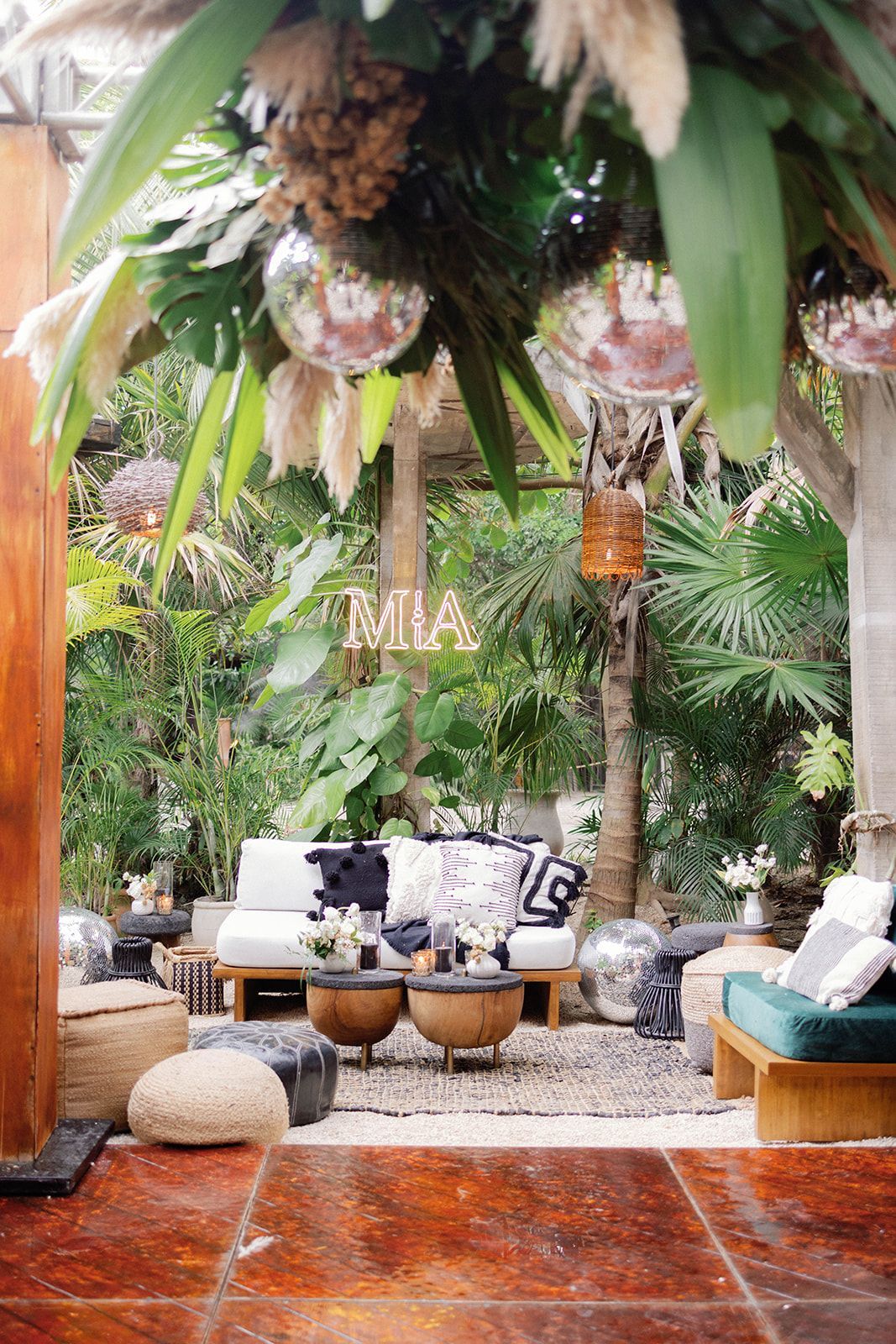 Outdoor lounge area with white sofas, coffee tables, and decorative plants.