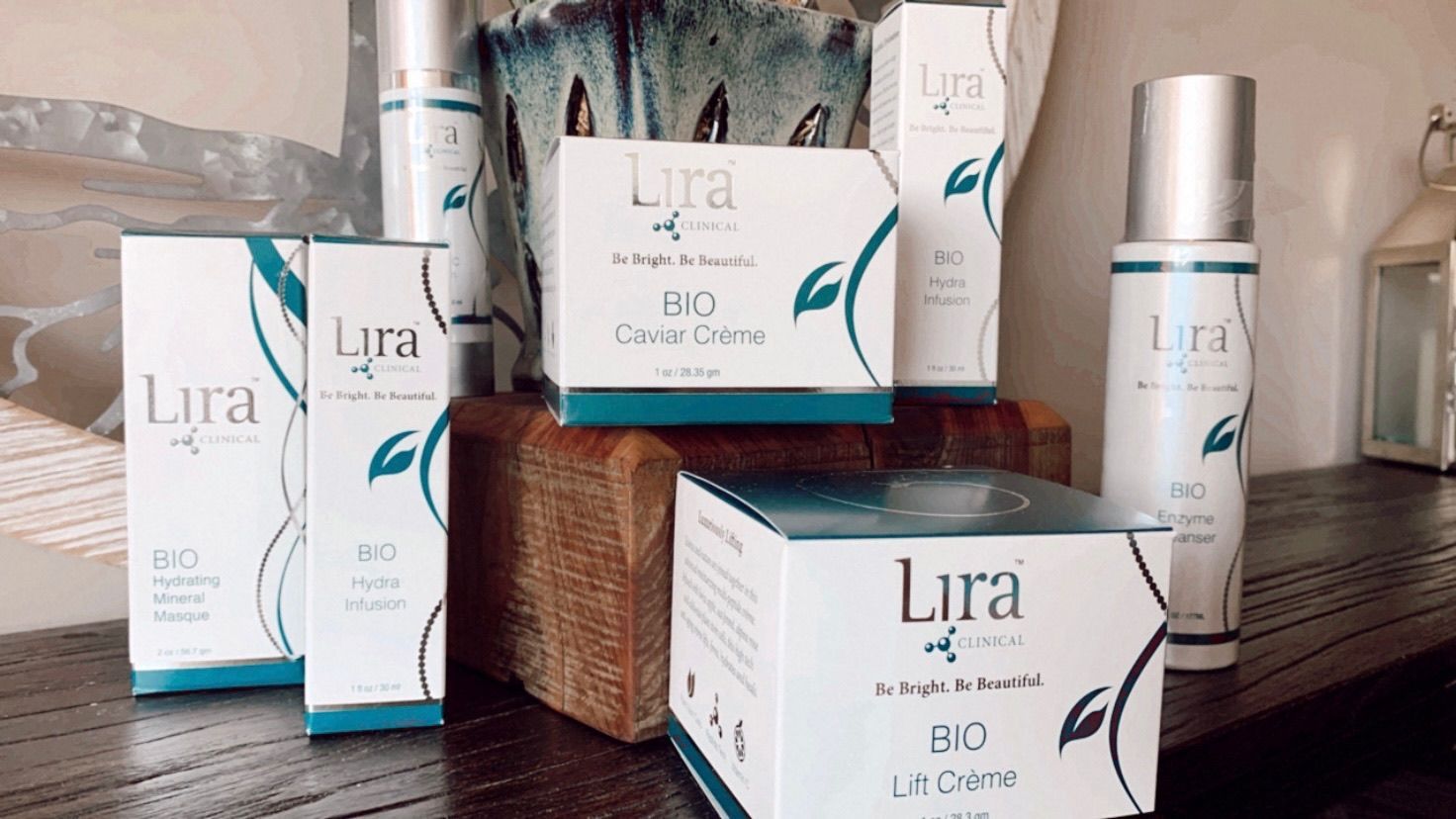 A variety of lira cosmetics are sitting on a wooden table.