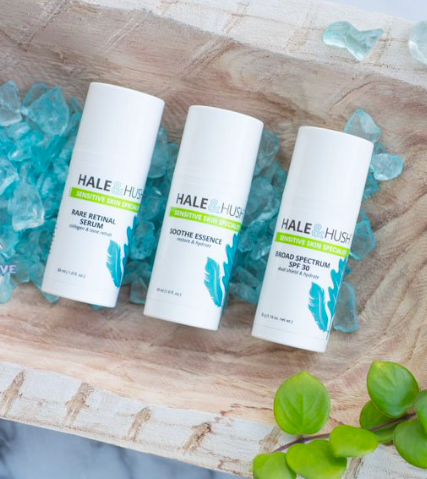 Three bottles of hale hus lotion are sitting on a wooden table