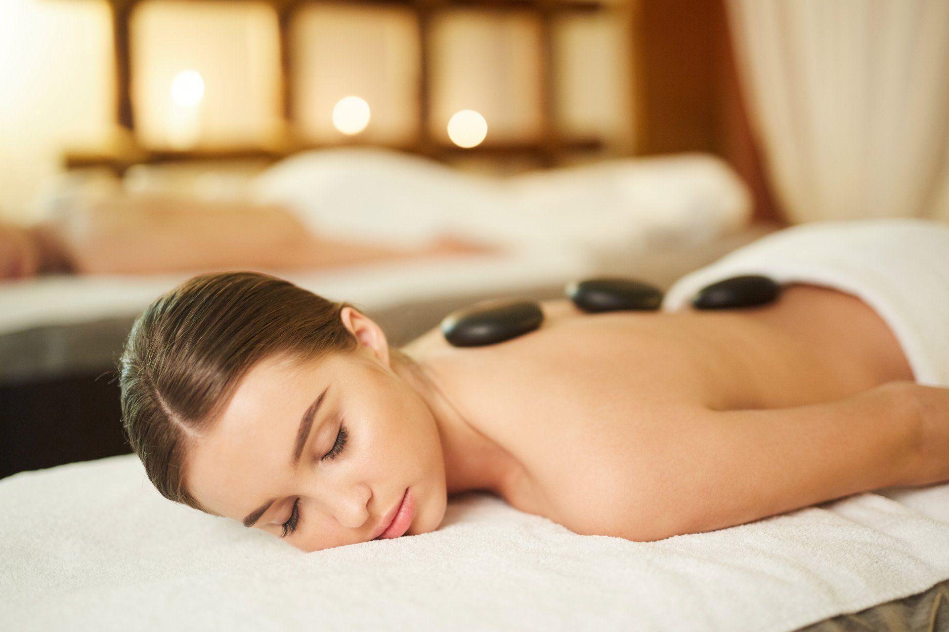 A woman is getting a hot stone massage at a spa.
