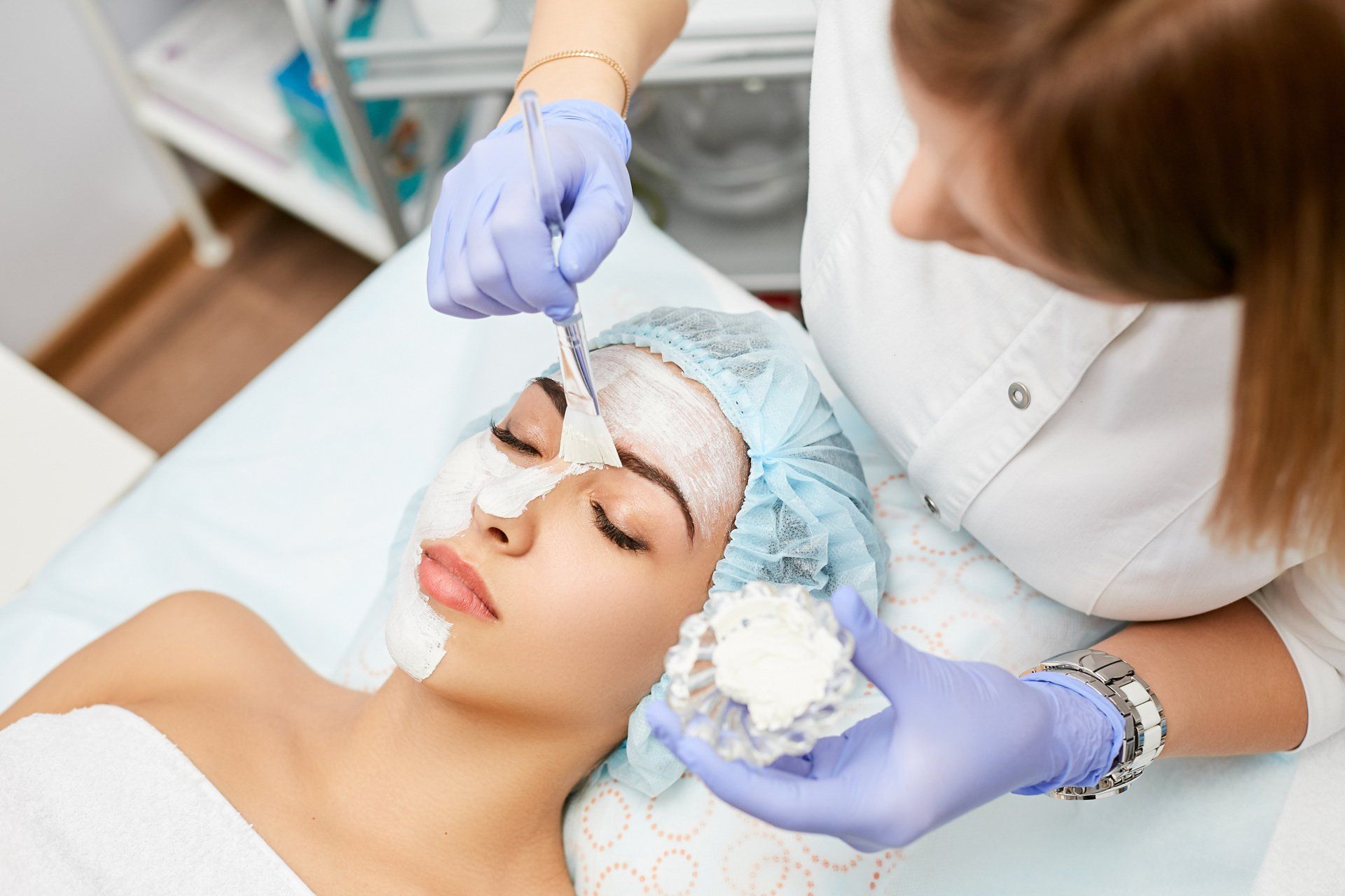 A woman is getting a facial treatment in a beauty salon.