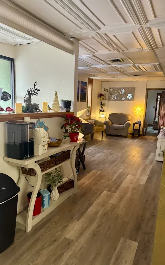 Cozy waiting area with armchairs, warm lighting, and wood flooring in a modern office or salon