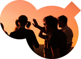 Des silhouettes contemplent le coucher du soleil. Une personne lève la main.