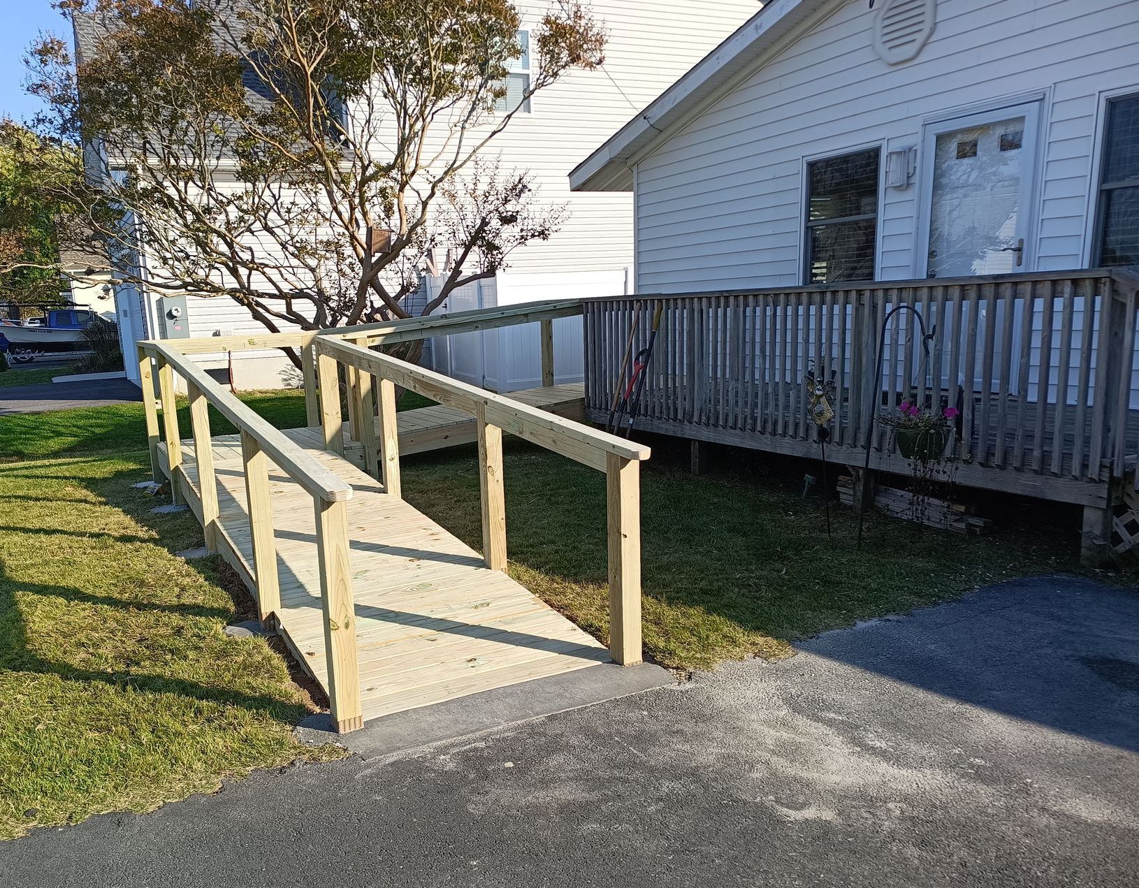Custom wooden wheelchair ramp under construction, attached to a single-story home with white siding in Ocean City MD
