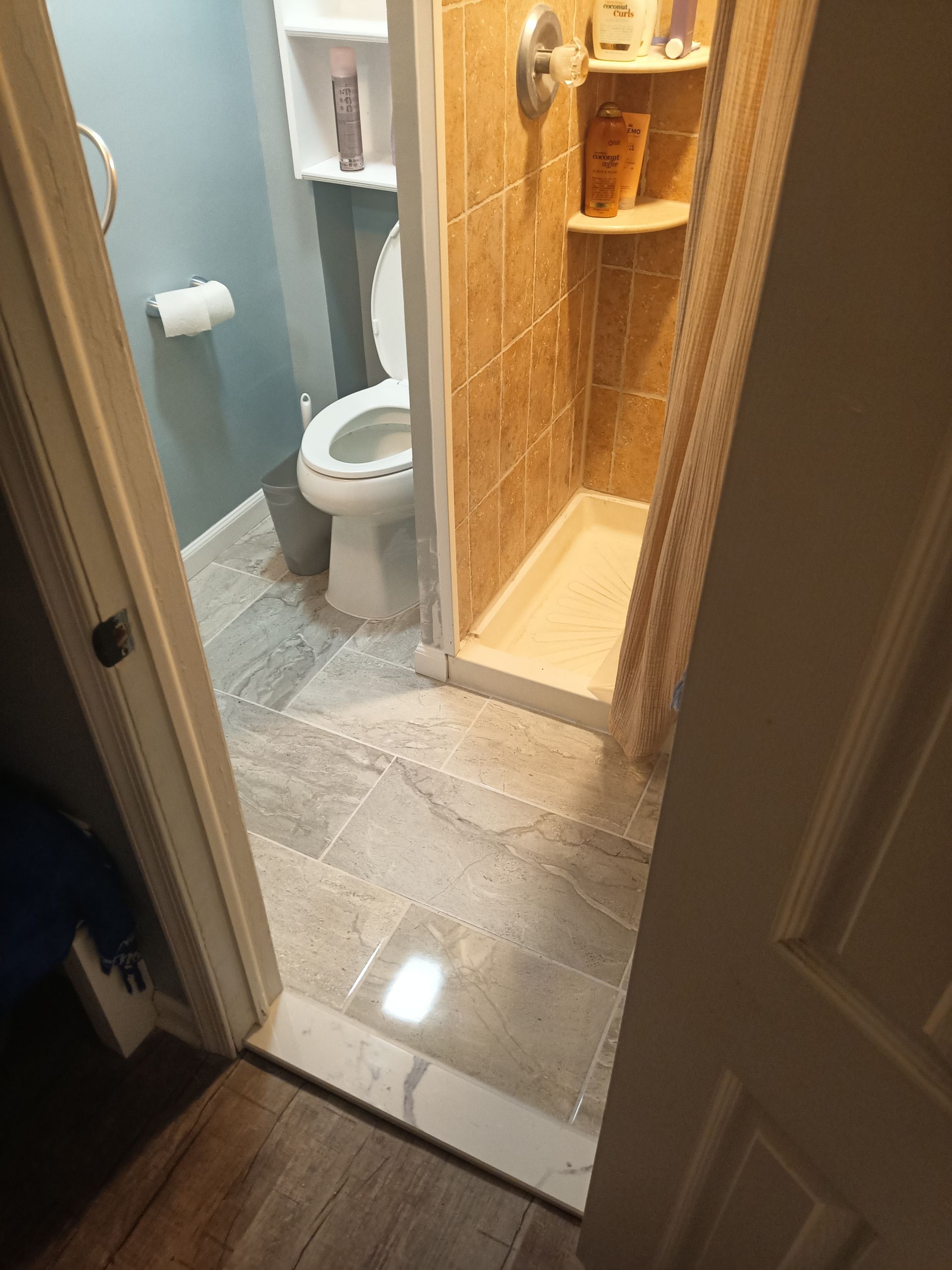 Modern bathroom remodel with new tile shower stall, updated toilet, fresh flooring, and painted walls in Ocean City MD