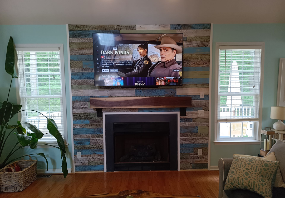 Living room with fireplace, TV, and blue and wooden accent wall.