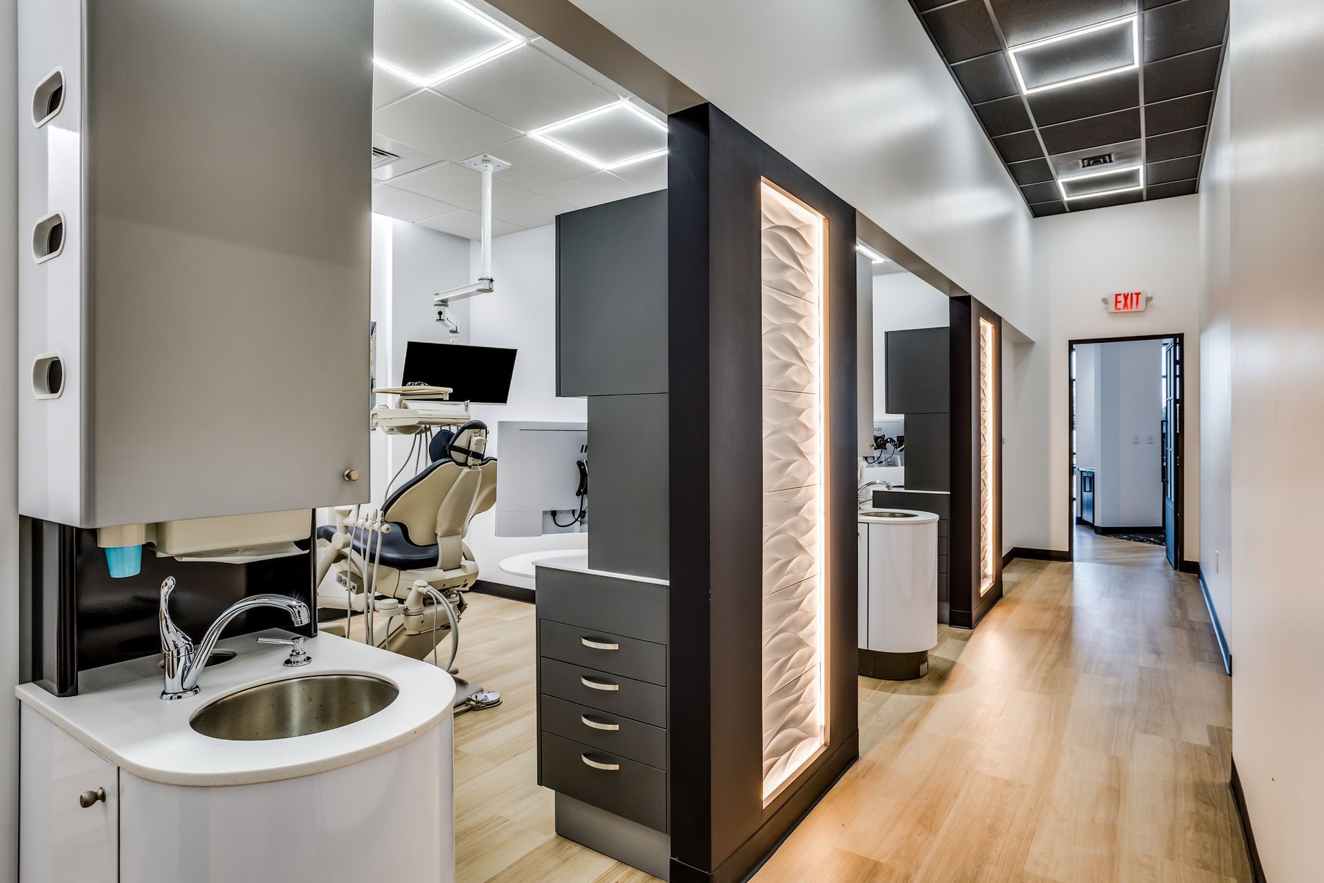 A dental office with a sink and a dental chair.