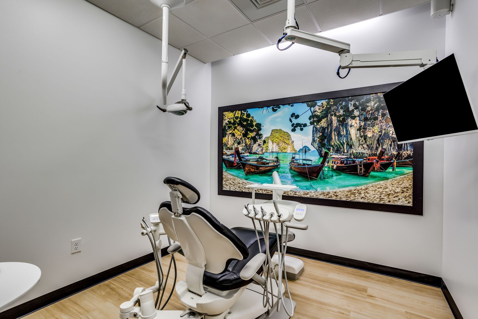 A dental office with a dental chair and a painting on the wall.