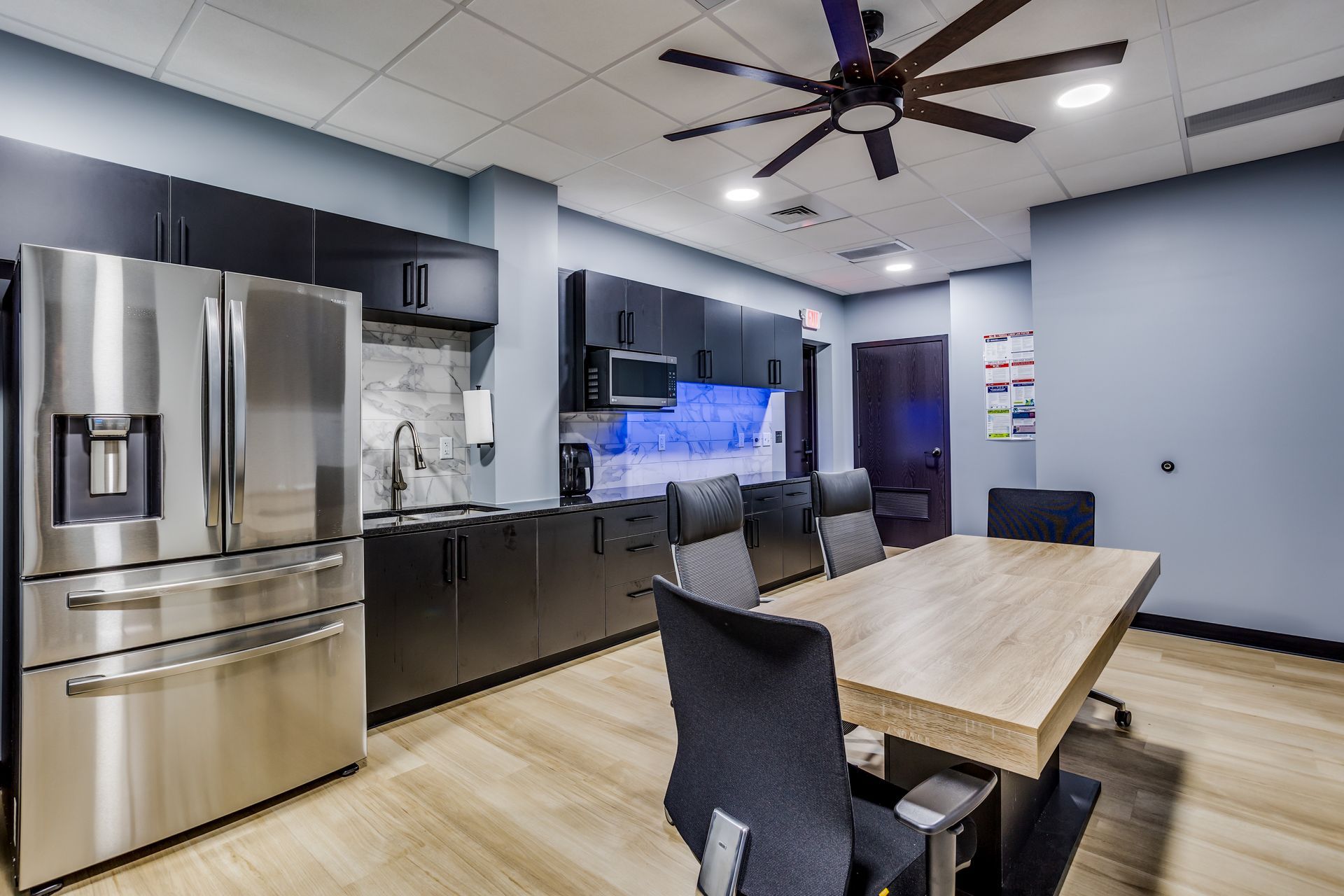 A kitchen with a table and chairs and a refrigerator.