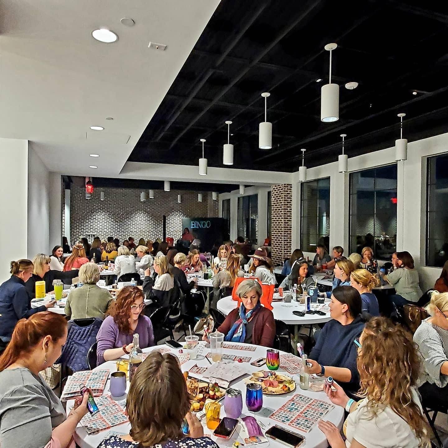 A large group of people are sitting at tables in a restaurant