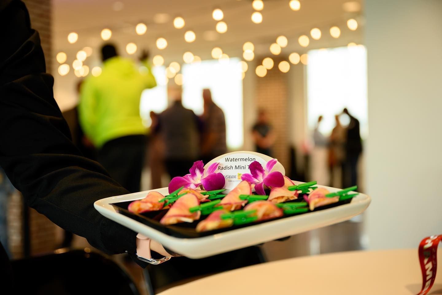 A person is holding a tray of food with flowers on it.
