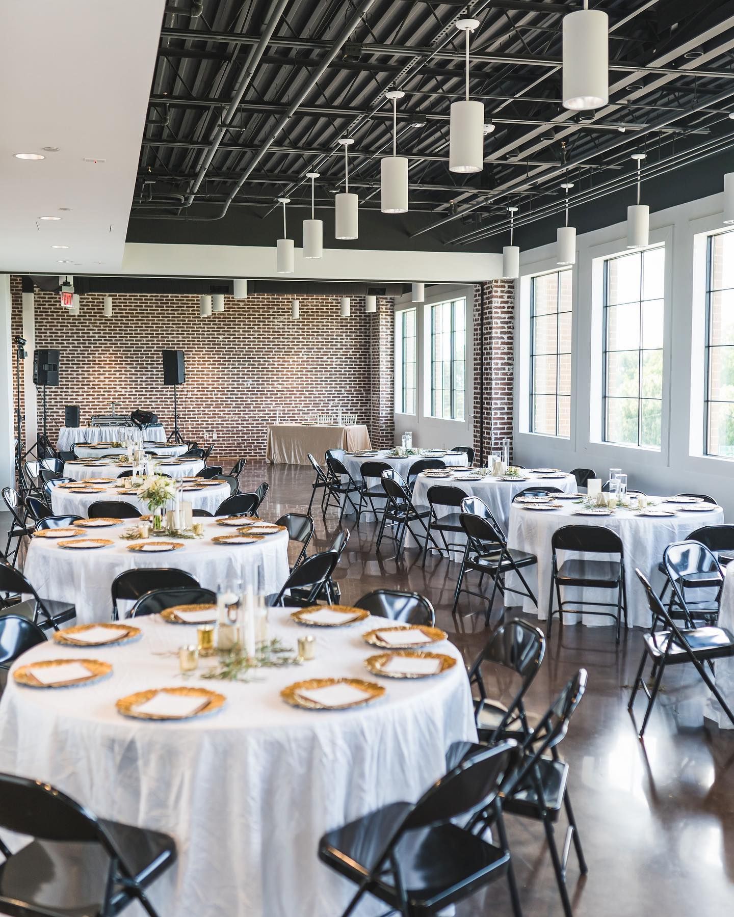 A large room with tables and chairs set up for a wedding reception.