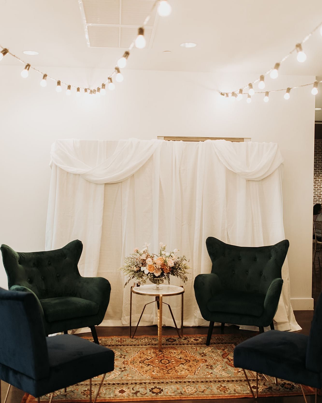 A room with three chairs and a table with flowers on it.