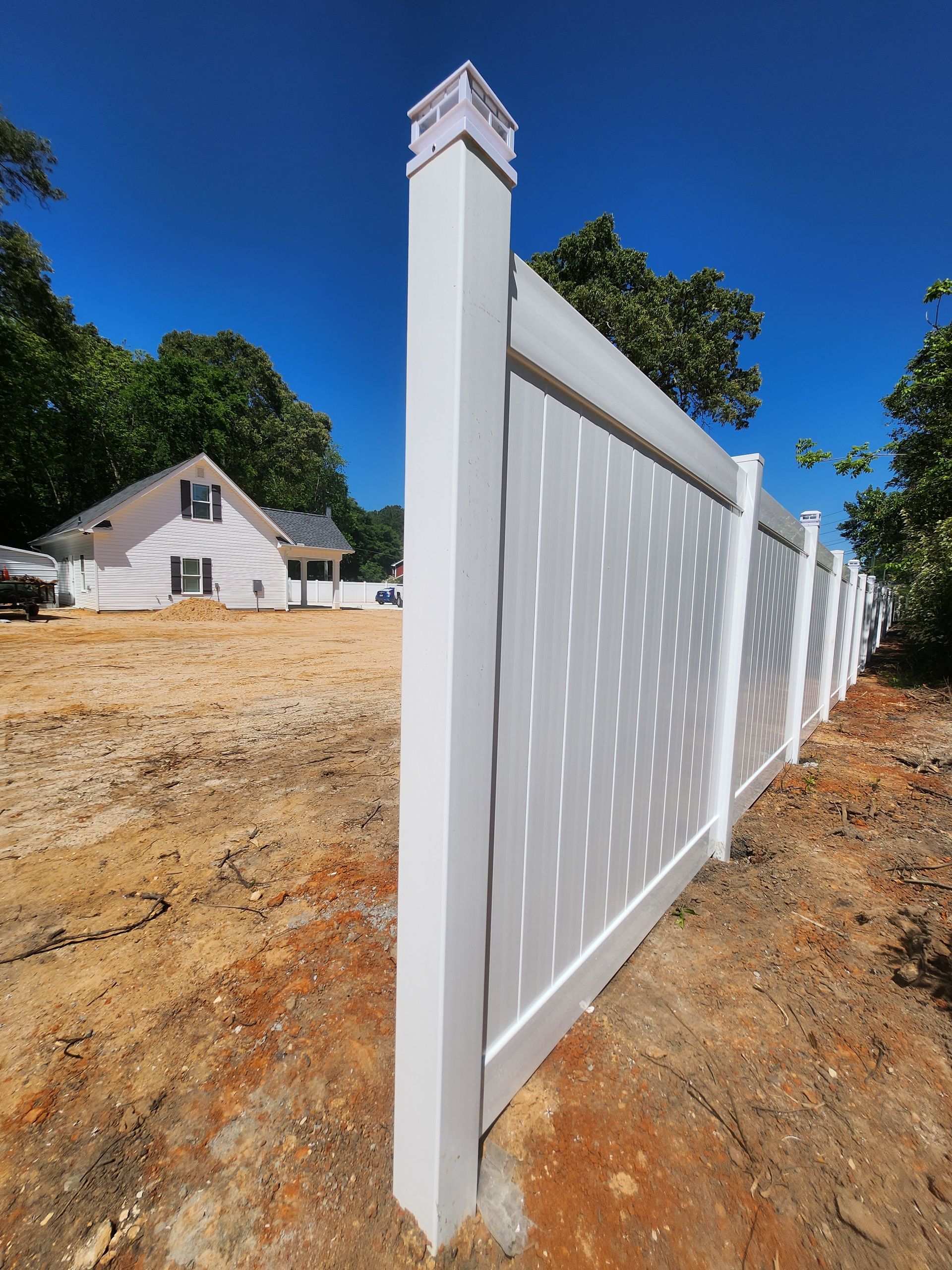 A white fence with a house in the background