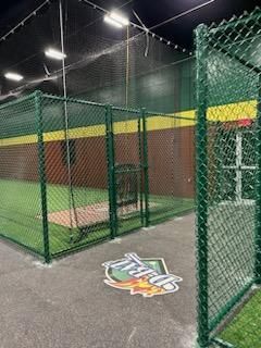 A green chain link fence surrounds a baseball field.