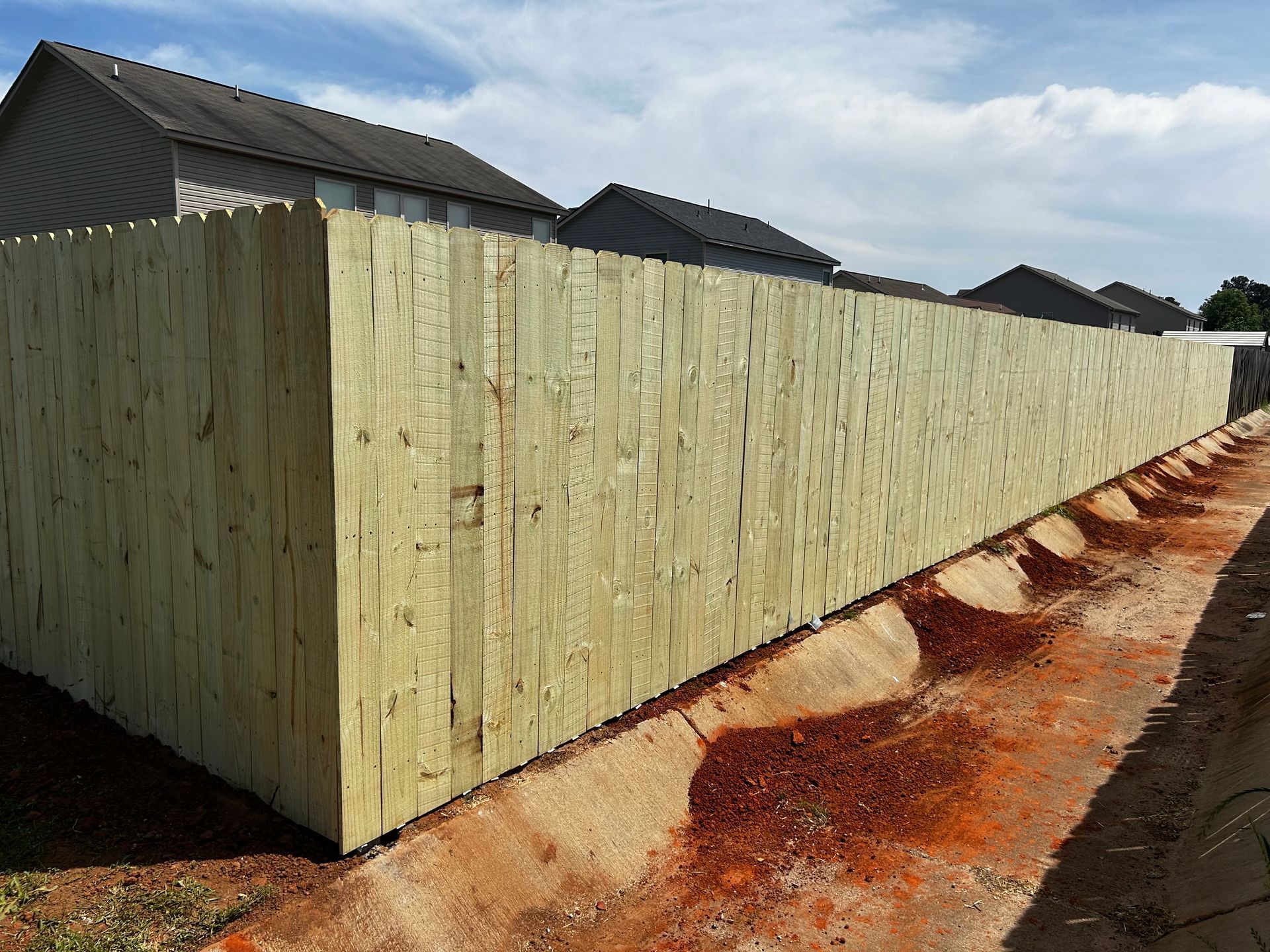A wooden fence is being built in front of a house.
