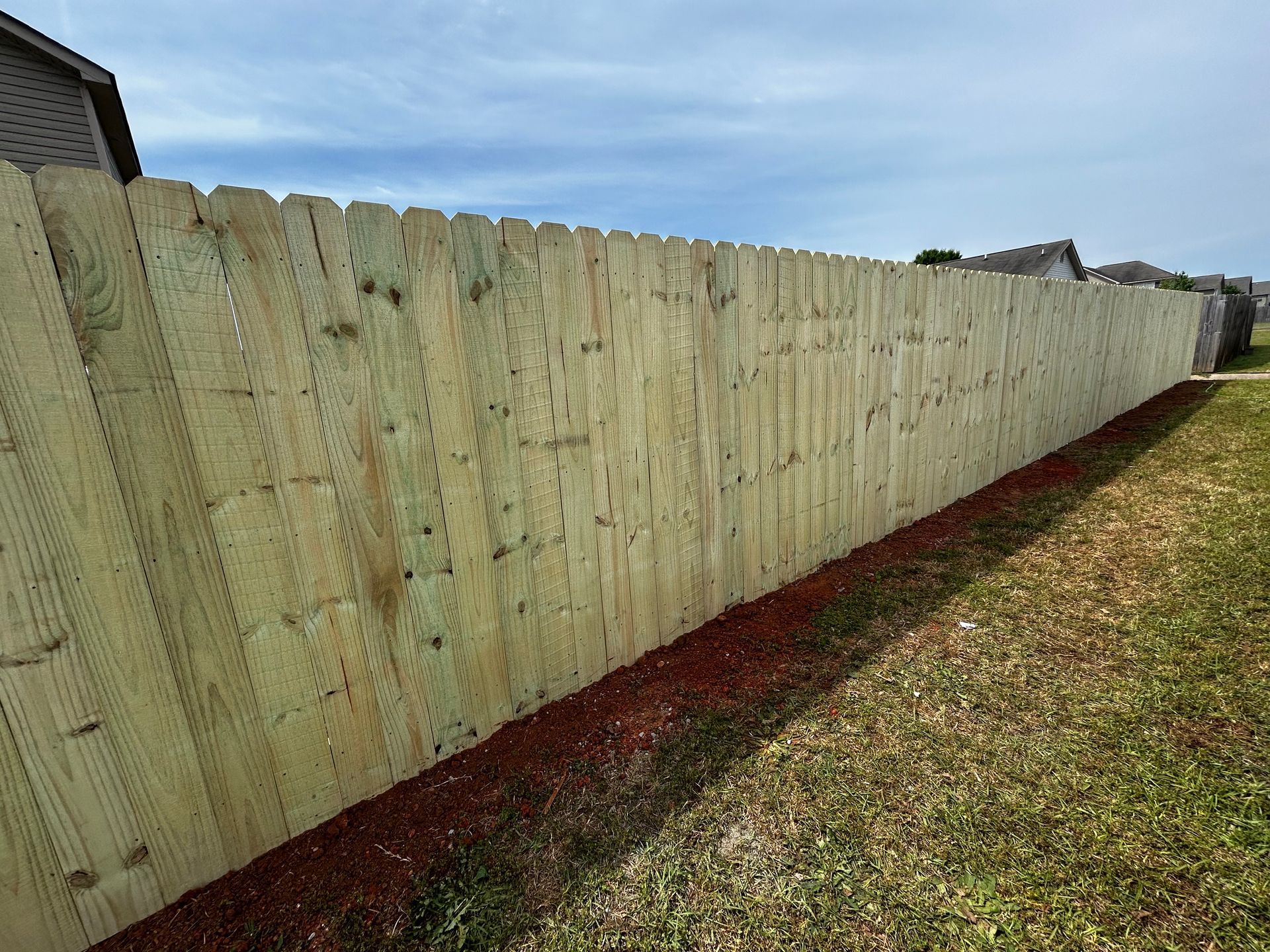 A wooden fence is sitting in the middle of a grassy yard.