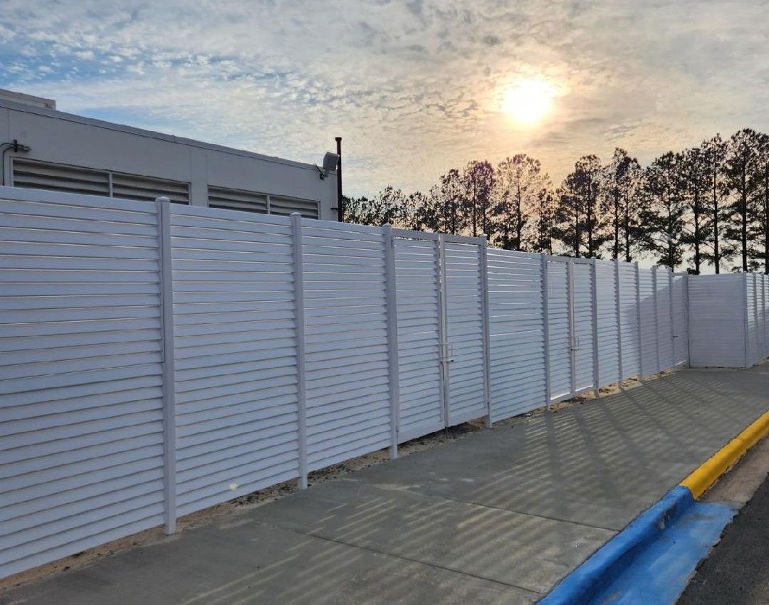 A black fence is surrounding a large building.