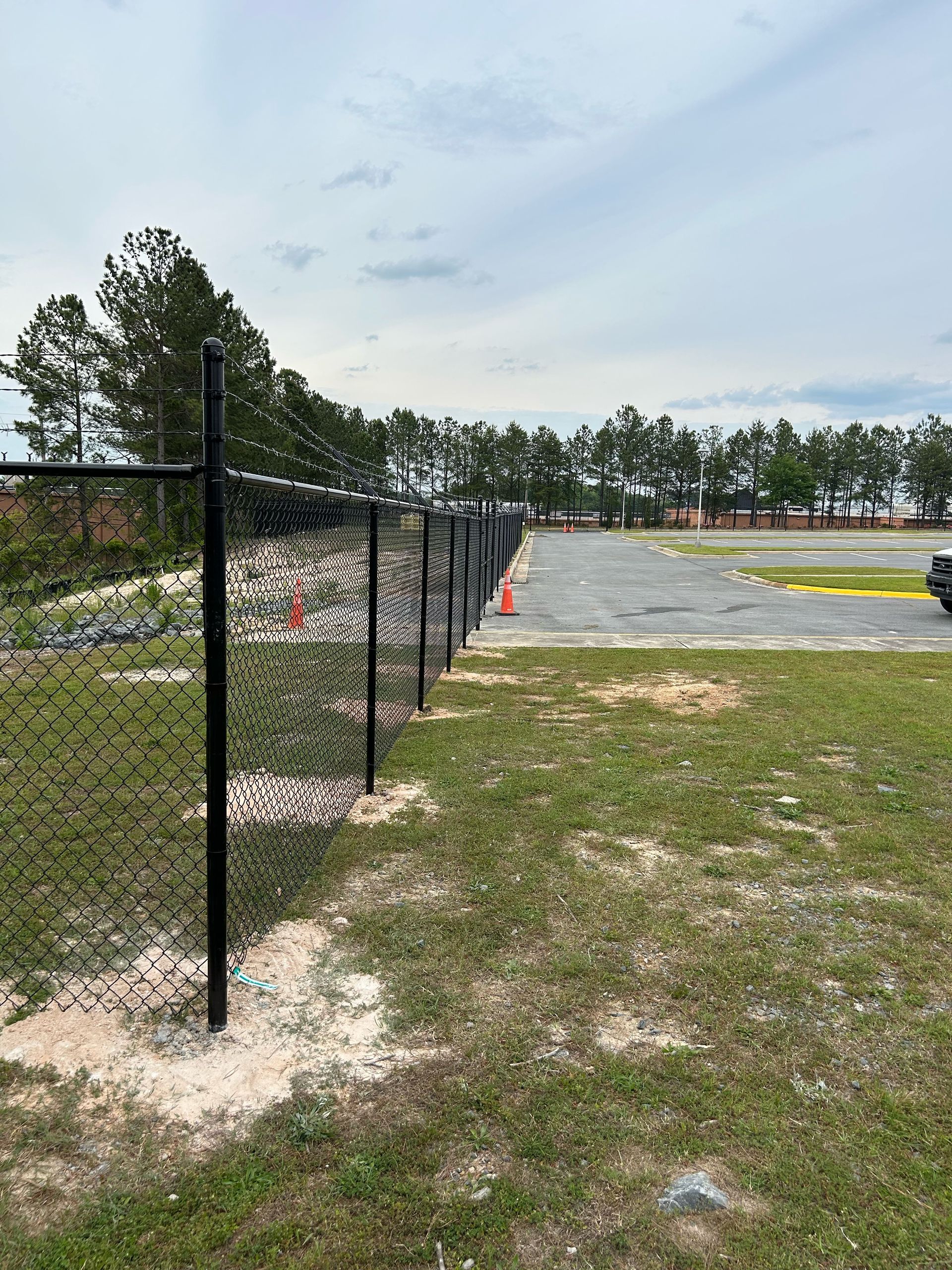 A chain link fence is sitting in the middle of a grassy field.