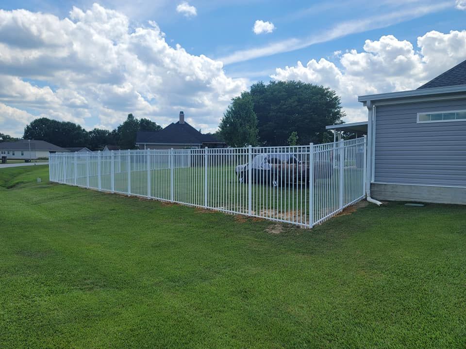 A small white dog is looking through a fence.