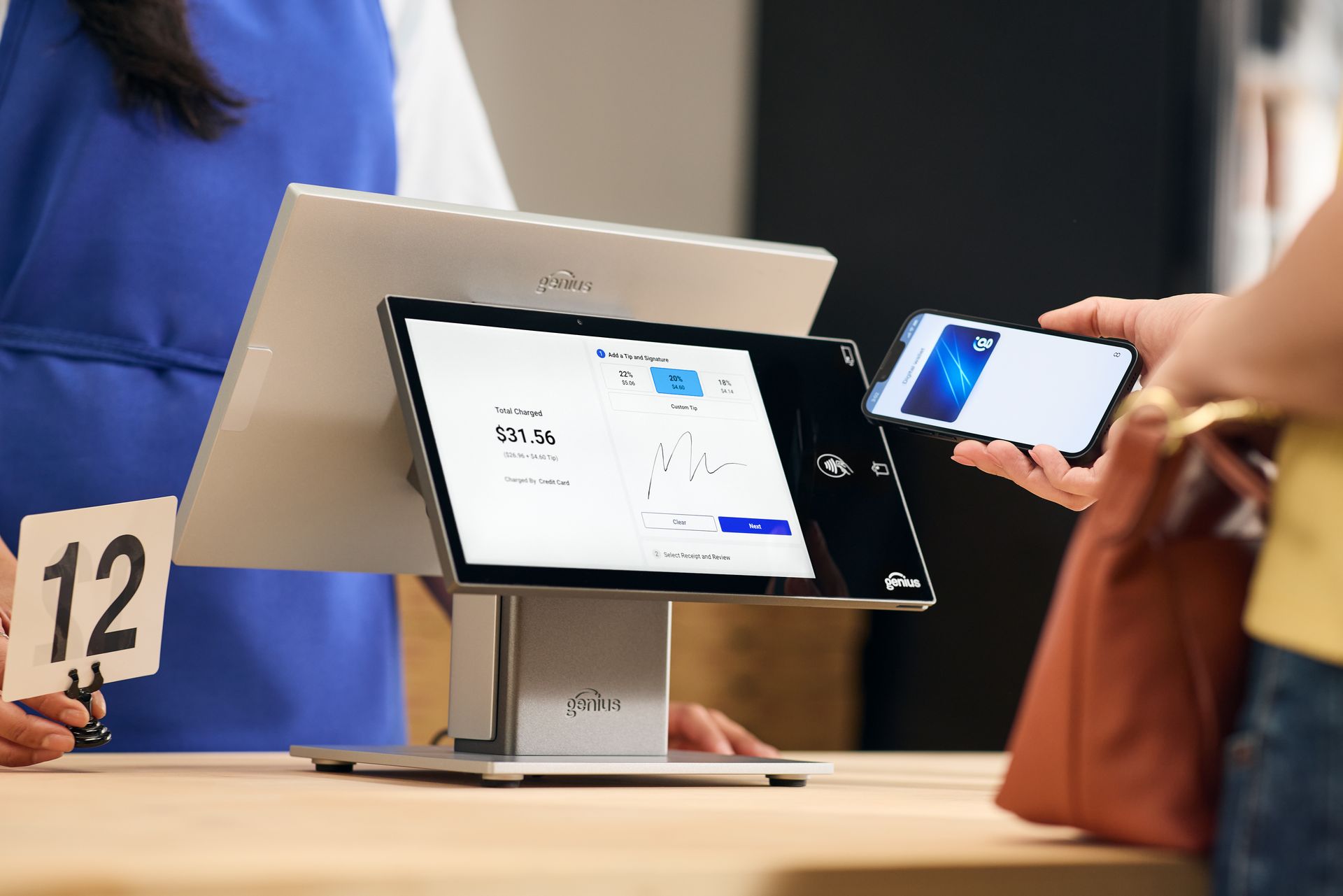 Black touchscreen point-of-sale system with two monitors, the primary display showing a blue screen with a logo.