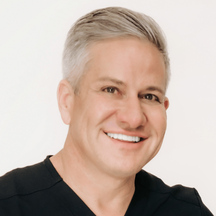 Professional headshot of Dr. Croley smiling in a blue blazer, medical director at Skin & Tonic in Pace, Florida.