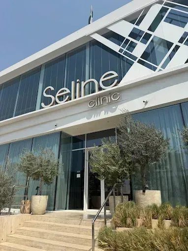 Modern clinic entrance with glass doors, steps, and “Seline clinic” sign above the facade