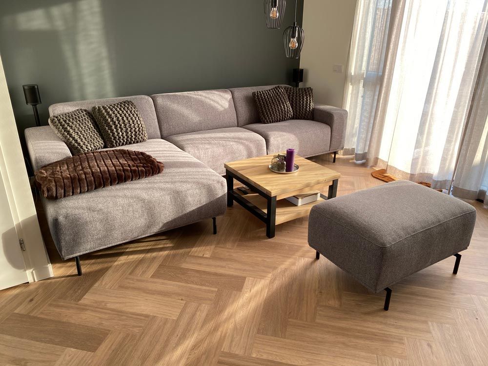 A Living Room With a Couch, Coffee Table and Ottoman — Bayside Carpets & Flooring in Wauchope, NSW