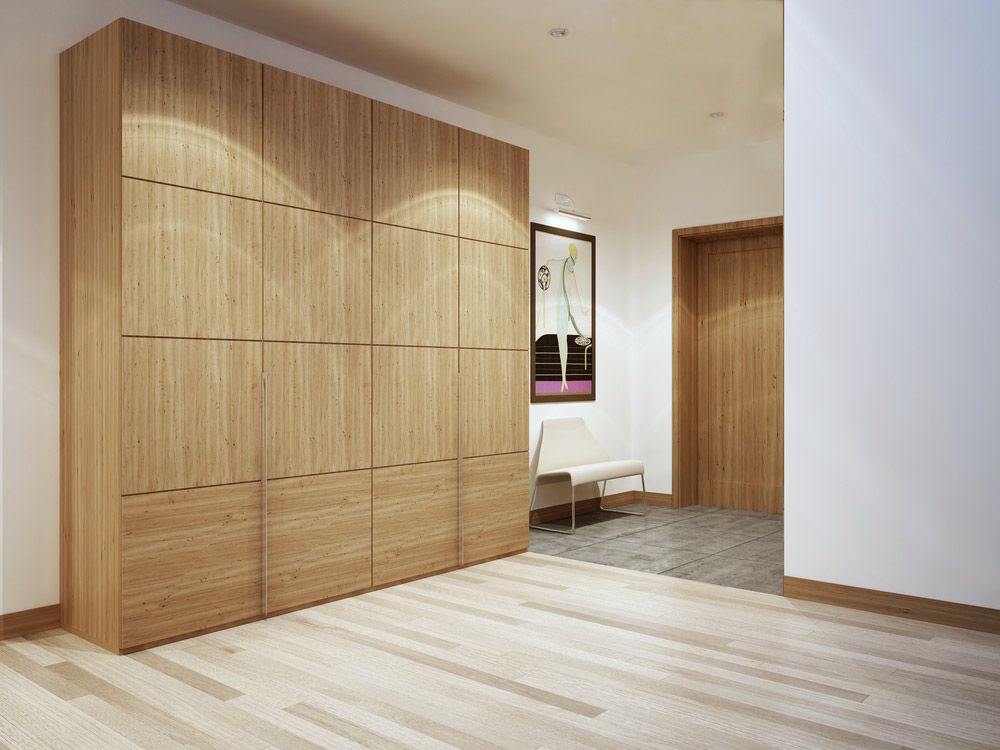 A Hallway With a Wooden Locker and a Chair — Bayside Carpets & Flooring in Bonny Hills, NSW