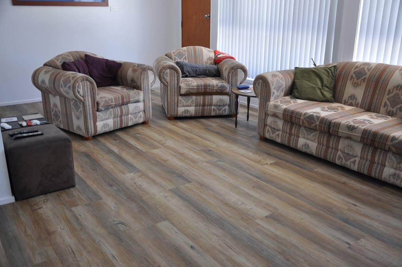 A Living Room Filled With Furniture and a Wooden Floor — Bayside Carpets & Flooring in Laurieton, NSW