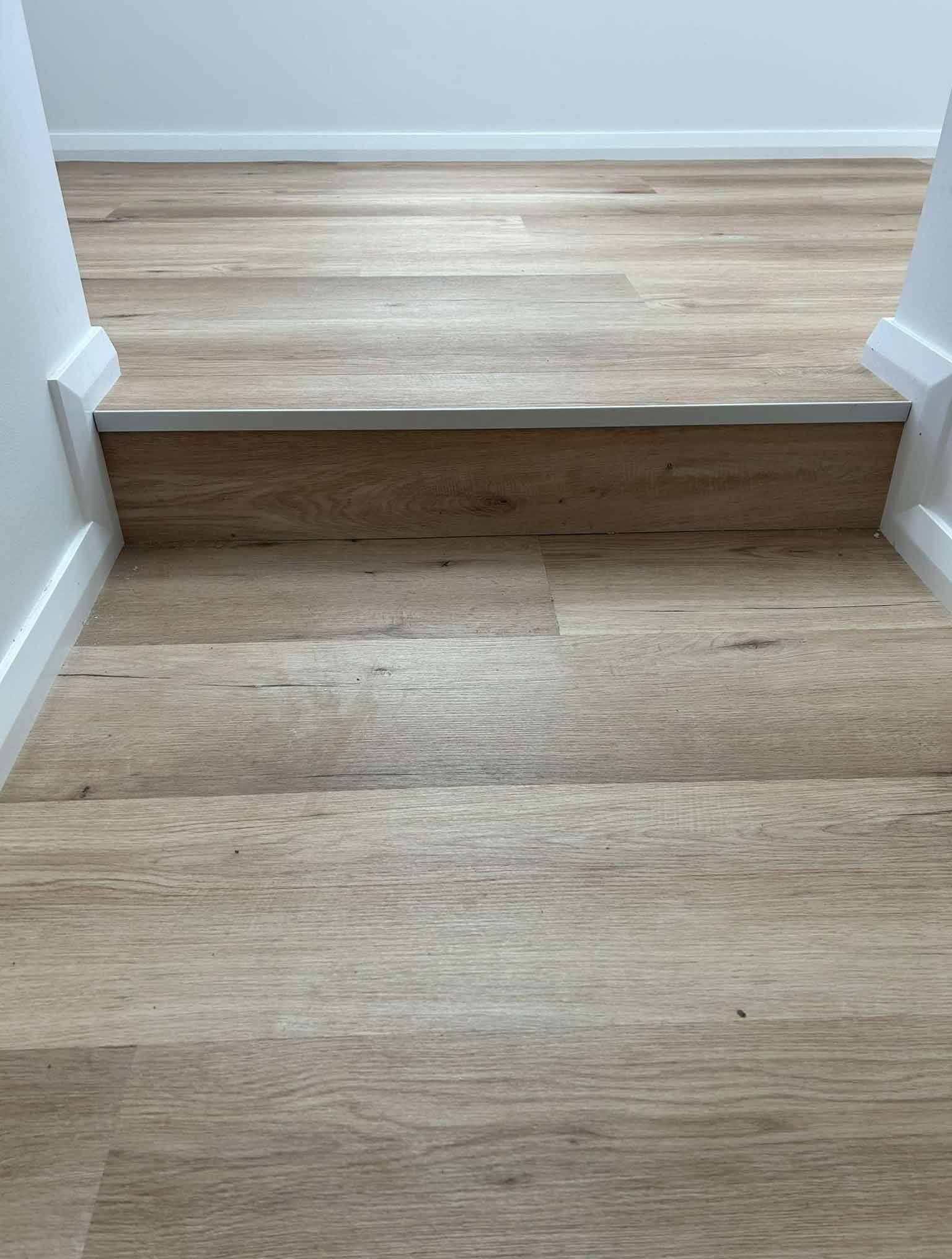 A Close Up of a Wooden Floor With Stairs in a Room — Bayside Carpets & Flooring in Laurieton, NSW