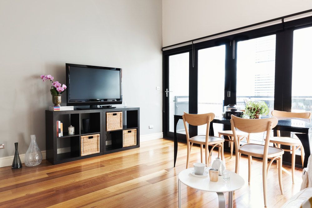 A Living Room With a Table, Chairs, and a Flat Screen Tv — Bayside Carpets & Flooring in Bonny Hills, NSW