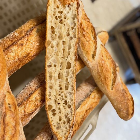 Cestino di baguette affettate con una crosta croccante dorata e una mollica soffice all'interno.