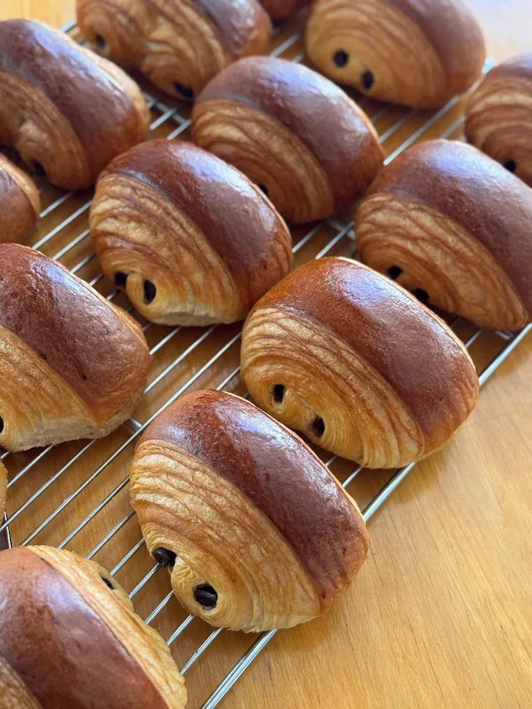 File di croissant dorati che si raffreddano su una griglia metallica