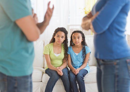 Two girls look on as parents argue.