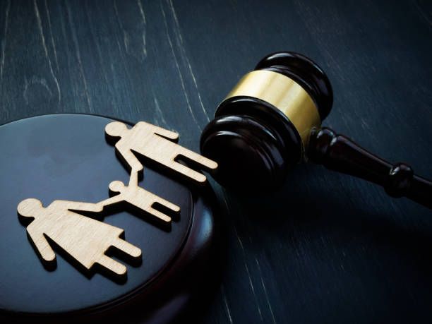 Family figurines and gavel on a dark surface, symbolizing legal proceedings related to family matters.