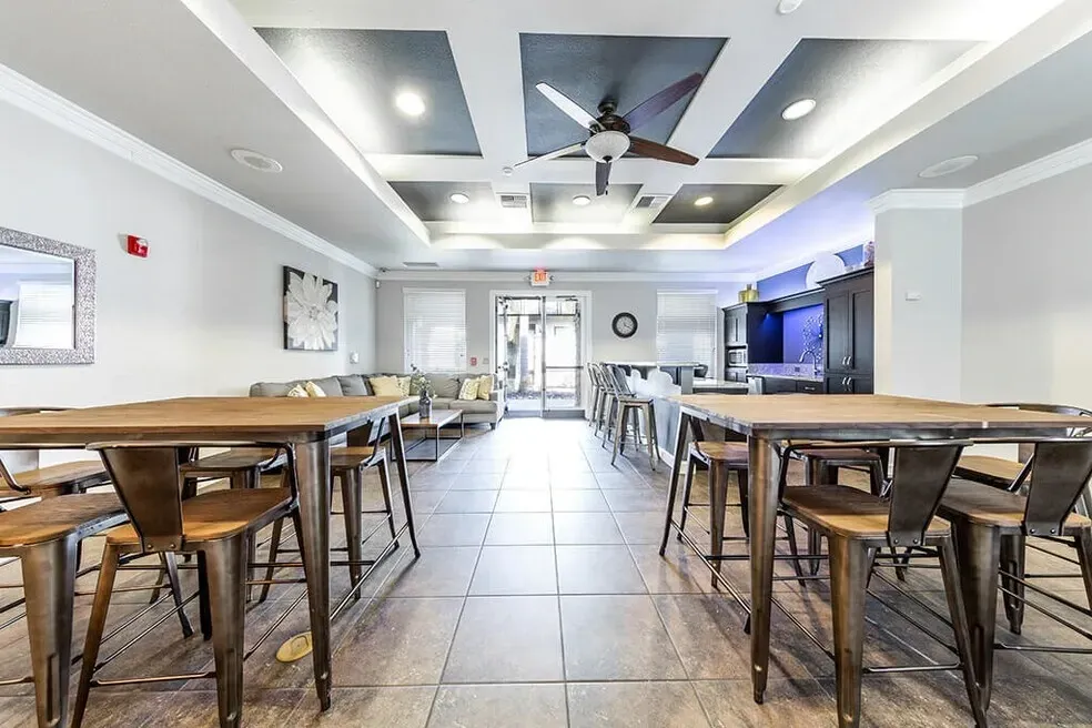Community lounge area with high-top tables, bar seating, and a sofa area.