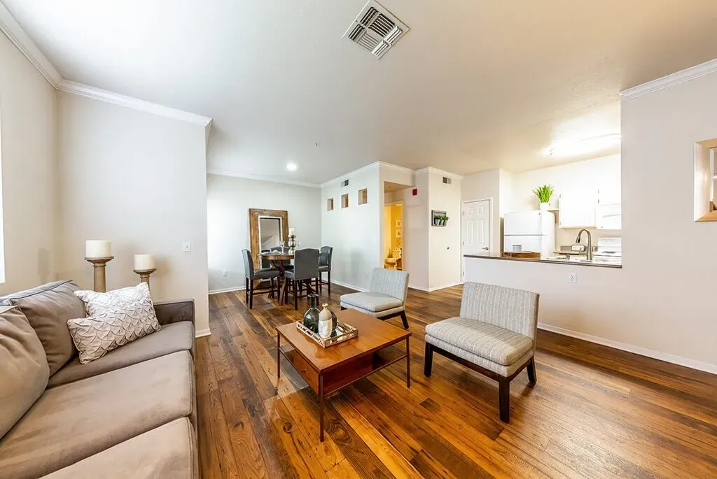 Living and dining area with hardwood floors, a couch, coffee table, and chairs.